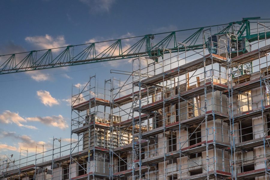 Boom,Of,A,Green,Construction,Crane,Over,The,Shell,Of