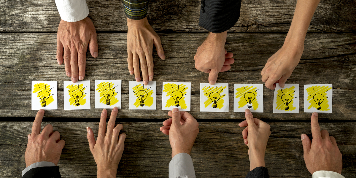 hands reaching towards paper lightbulbs future law firm